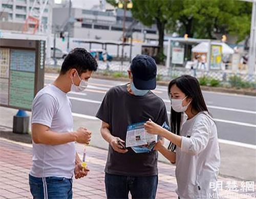 '图3:二零二一年六月二十七日,法轮功学员们在向过路行人讲法轮功真相'