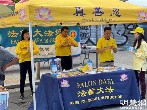 '图1:法轮功学员展位上现场展示五套功法'