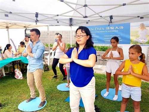 '图2:南希参加弘法活动,展示法轮功功法。'