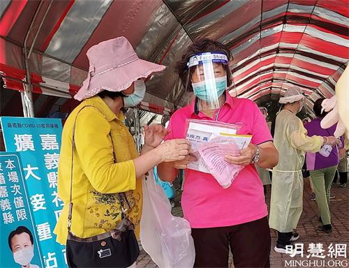 '图3~4:在嘉义县南新国小疫苗施打站,法轮功学员派发特刊,告诉人们诚念九字真言会带来平安福报。'
