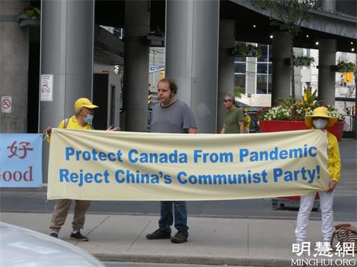 '图13:一位在多伦多政府工作的男士主动走过来向法轮功学员了解真相'