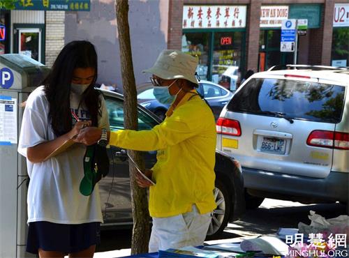 '图2:西雅图民众在结束中共迫害法轮功的征签表上签名。'