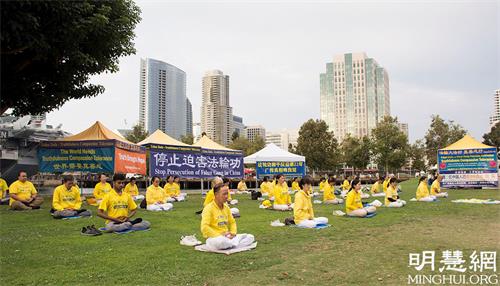 '图1~3:2、3:加州圣地亚哥法轮功学员在当地著名景点中途岛航母博物馆附近举行集体炼功'