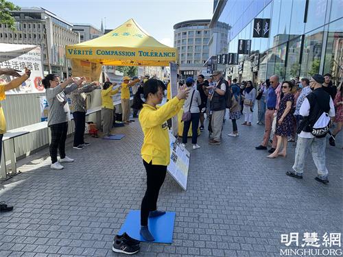 图1: 法轮功学员在布鲁塞尔中心商业区举办活动揭露中共持续二十二年的迫害真相