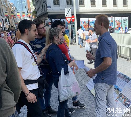 图2:威尔弗里德·杜尚(wilfried.duchamps) (右一)与了解法轮功的民众讲迫害真相