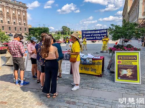 '图1:法轮功学员在斯德哥尔摩市中心国会大厦旁举办“法轮功反迫害二十二周年”讲真相活动。'