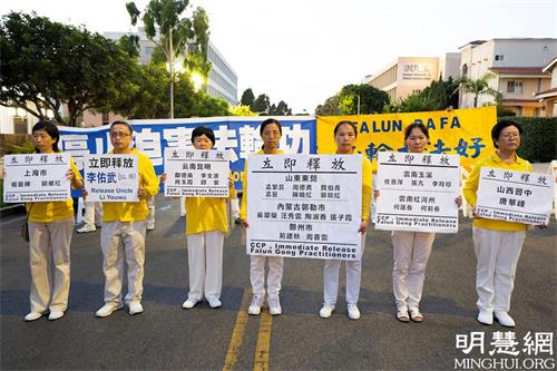'图9:集会上,部份来自中国大陆的法轮功学员手举营救展板,呼吁释放所有被非法关押的法轮功学员。'