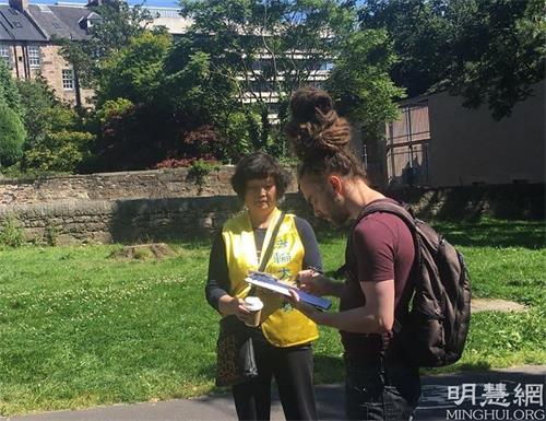 '图6:来自美国的留学生(右)签名支持反迫害,希望了解更多'
