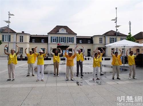 '图1:法轮功学员在德莱蒙火车站广场炼功'