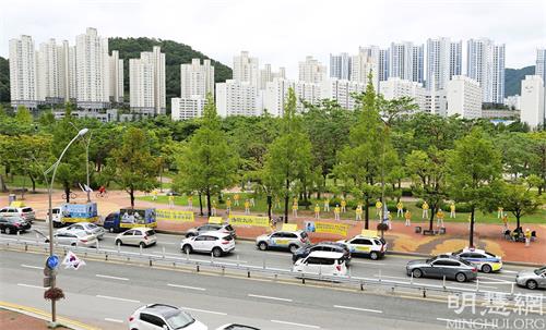'图1:釜山法轮功学员举办揭露中共对法轮功的迫害以及弘扬法轮大法的车队游行。'