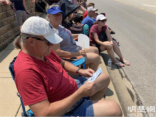 图12:游行前索尔德纳(Soeldner )夫妇拿取法轮功资料专心阅读。