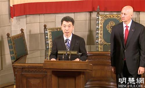 图1:2021年6月24日,美国内布拉斯加州州长皮特·里基茨(Pete Ricketts)在州议会大厦宣布7月为“共产主义受害者纪念月”。图为法轮功学员王先生发言,身旁是州长。