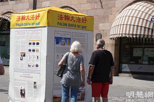 '图6:人们驻足在真相展板前阅读'
