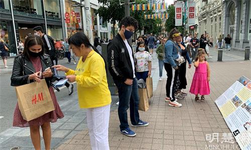 '图1~2:比利时安特卫普著名的梅尔购物街(Antwerp Meir Street)上,路人驻足了解法轮功真相。'