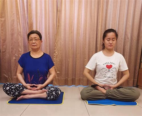 '梁琼予(右)和奶奶一起打坐'
