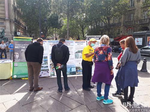 '图4:165618:八月八日下午,在巴黎圣米歇尔广场游人们向法轮功学员了解真相'