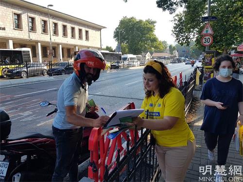 '图9:一位骑摩托车的男士停下来在要求解体中共的请愿信上签字'