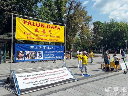 '图1:法轮功学员在维尔纳市中心文卡斯·库迪尔卡斯广场举办讲真相活动'