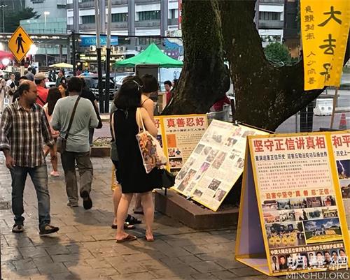 '图2~4:游客驻足看展板、听真相。'