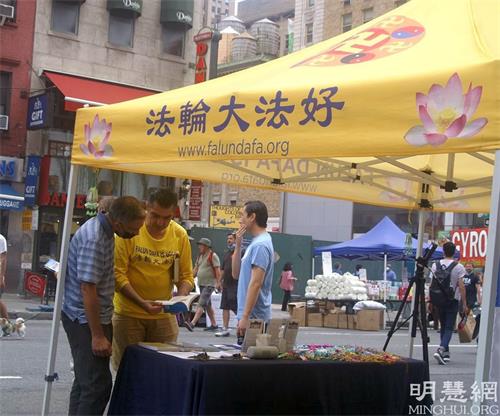 '图4:Salvatove Branciforte(左一)在听法轮功学员对法轮功书籍的介绍'