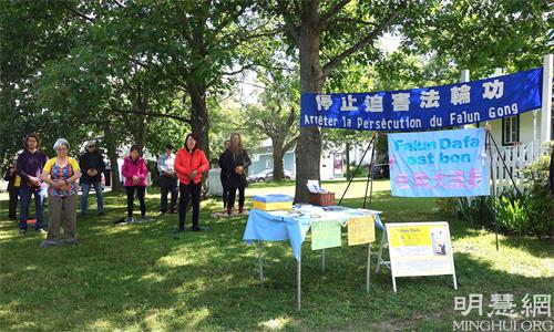 '图1~2:7月31日,法轮功学员在魁北克圣安德杨(St-Adrien)集市上讲真相,集体炼功,征集反迫害签名。'