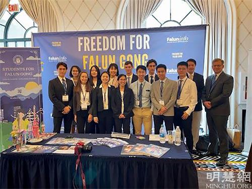 '图1:12位法轮功学生会的成员与2位法轮大法信息中心的成员一起在法轮功展位前'