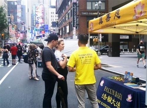 '图7:电脑工程师迈克尔(Michael,左一)和女朋友艾丽卡(Aryca,左二)在听法轮功学员讲述真相。'