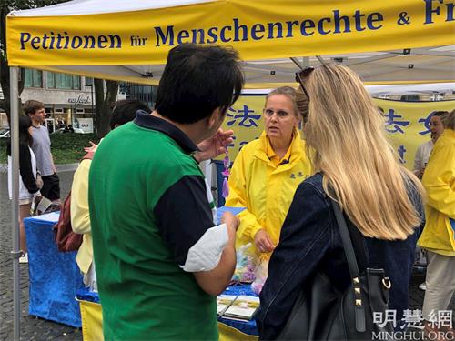 '图5~8:民众聆听法轮功学员讲真相并为反迫害签名'