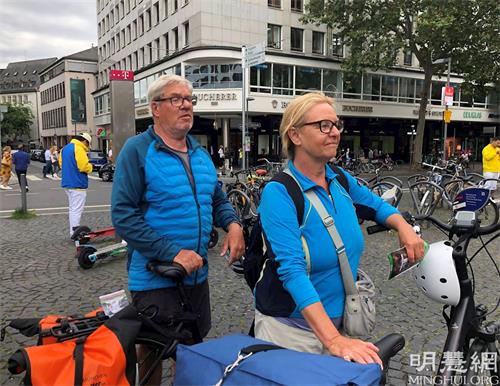 '图12:玛蒂娜和戈尔德骑车经过时为反迫害签名'