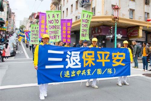 '图:海外法轮功学员游行队伍中呼吁“三退保平安”的横幅'