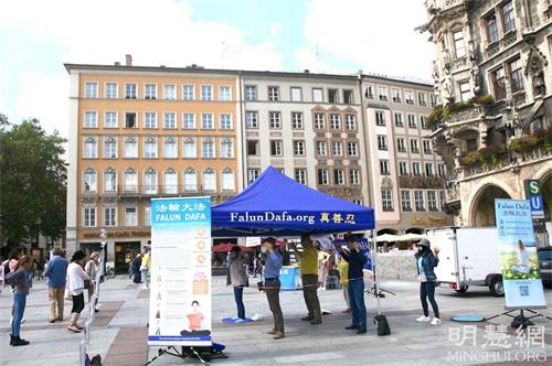 '图1:二零二一年九月一日,法轮功学员在德国慕尼黑玛琳广场(Marienplatz)举办真相日活动,图为法轮功学员展示功法。'