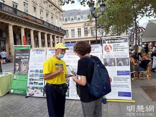 '图2~3:巴黎民众在征签表上签字,支持法轮功反迫害。'