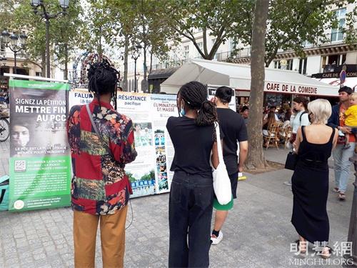 '图4:巴黎民众在柯莱特广场观看展板,了解法轮功真相。'