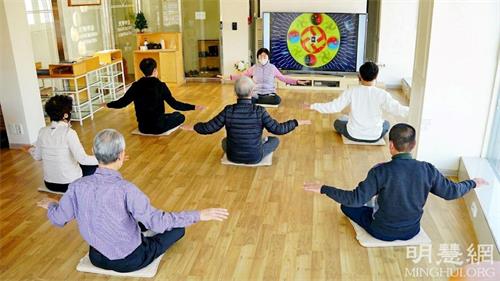 '图1:二零二二年一月四日到十二日,韩国首尔天梯书店在开业六年以来迎来了第100届“法轮大法九天学习班”。图为参加二零二一年十一月份九天班的人们学习法轮大法第五套功法的场景。'
