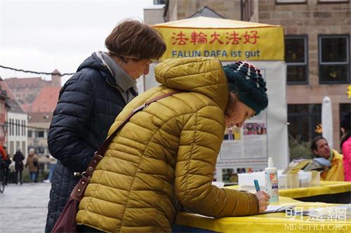 '图2~4:二零二二年一月十五日,弗兰肯地区的部份学员在纽伦堡传播真相,民众了解真相后,签名支持法轮功学员反迫害。'