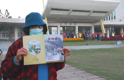 '图4:一位散步的女士展示在晨炼现场得到的真相期刊“天地苍生”。'