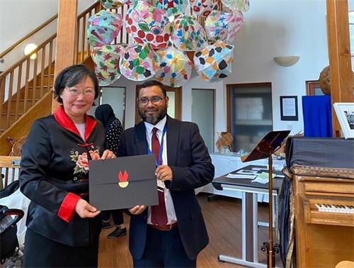 '图1:马乌姆•塔鲁克达尔(Cllr Maium Talukdar)到场给获奖者,法轮功学员孙女士颁奖。'