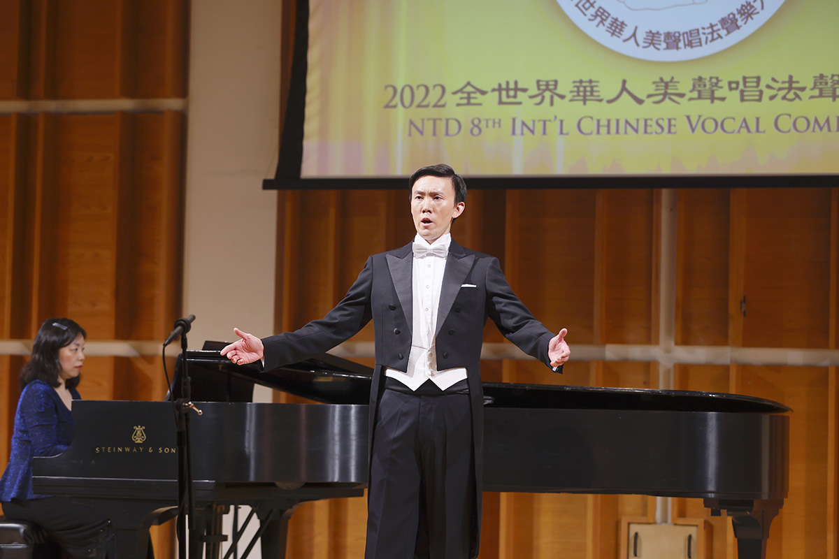图5:来自美国纽约的选手、男声组铜奖获得者之一,李新在演唱《大江东去》。(大纪元)