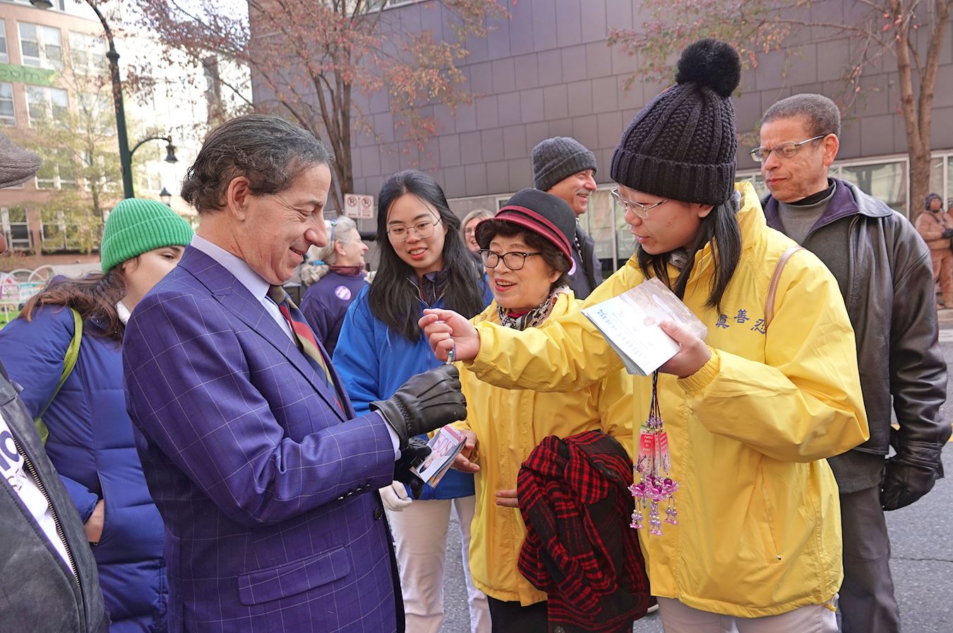 '图11:法轮功学员向马里兰州联邦众议员拉斯金(Jamie Raskin)递上法轮大法简介传单,并赠送莲花。'