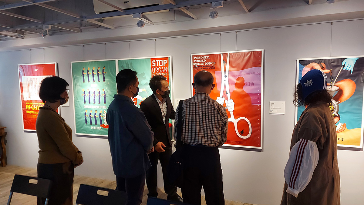 图2:海报展导览员(中)正在为参观者作解说。