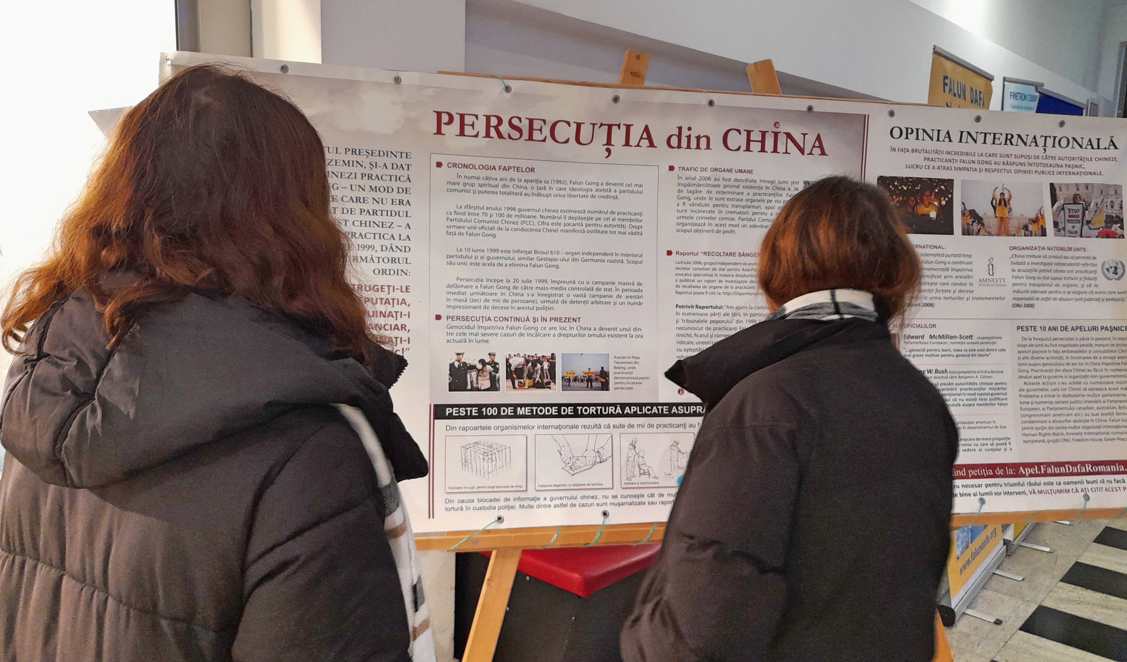 图5:伊奥娜和她的朋友达里亚在认真阅读真相展板。她认为媒体应该有勇气报道中共的罪行。