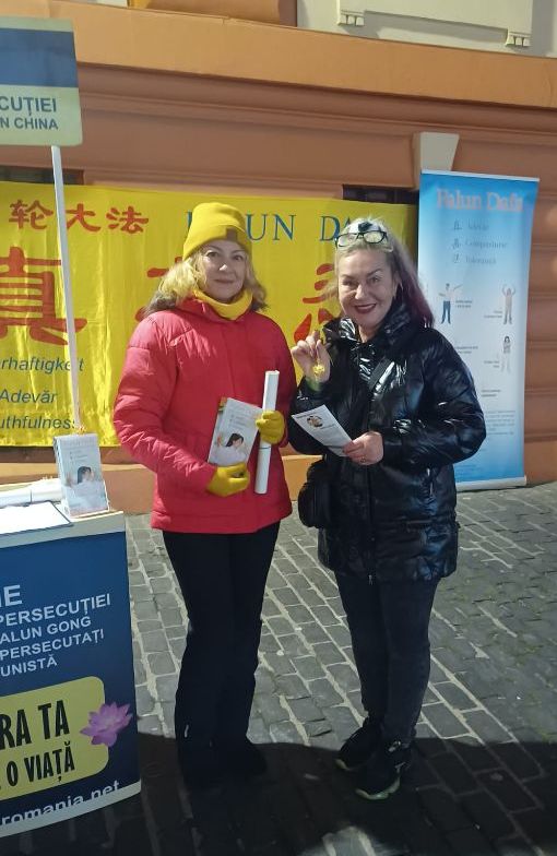 图4:在热闹的国庆和圣诞市场上,许多人为收到法轮功学员赠送的二零二三年真相小挂历而感到欣喜,一位女士说:“我每年都期待着将挂历放在我小女孩的房间里。”