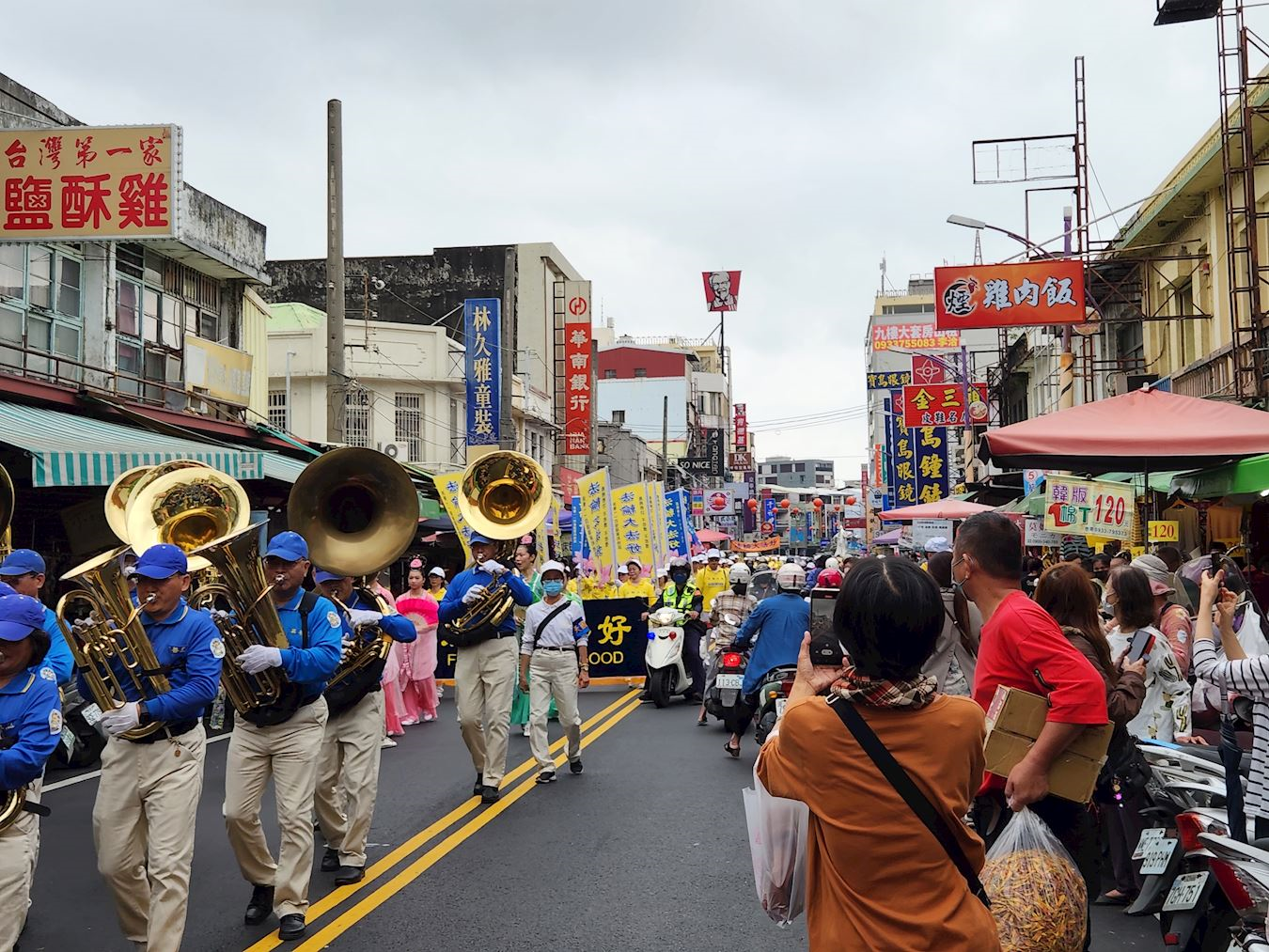 '图2:民众观看游行队伍,争相拍照。'