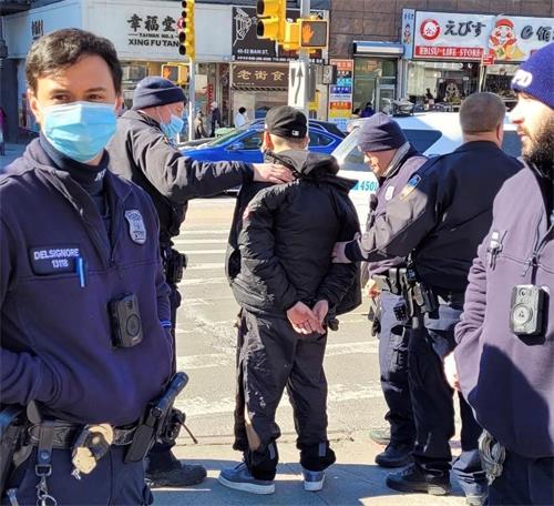 '图1:二月十五日中午时分,纽约市警109分局的警察在法拉盛缅街与凯辛娜大道的交界处,拘捕了近日来,多次暴力袭击法轮功多个真相点的疑犯。(法轮功学员提供)'