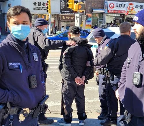 '图1:二零二二年二月十五日,警方在纽约法拉盛逮捕了袭击法轮功真相资料摊的郑步秋。(由法轮功学员提供)'