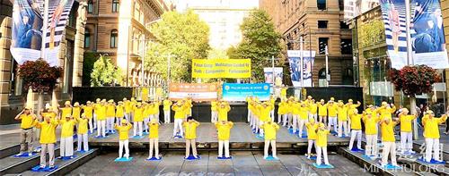 '图1:集会当天清晨,法轮功学员正在向人们展示法轮功第二套功法。'