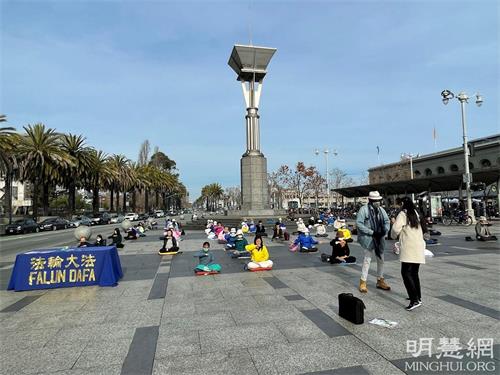 '图1~3:大年初五,二零二二年二月五日,旧金山法轮功学员来到了渡轮大厦前的广场上,伴着祥和的炼功音乐,展示了法轮功的优美的五套功法。'