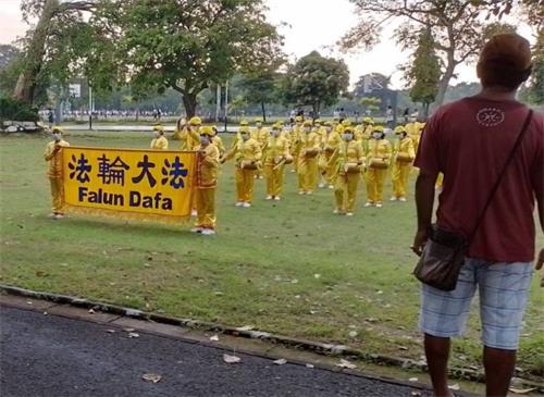 图2:路人慢下脚步观看腰鼓队表演