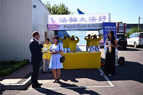 图8:二零二二年三月十九日,在墨尔本“盆景兰花展”上,澳洲联邦议员穆里诺博士(Daniel Mulino,左)观看法轮大法学员功法展示并与学员交谈。