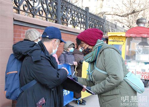 '图12:西人女士阿波隆(右)签完名后表示希望迫害尽快停止。'